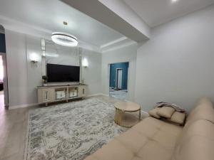 a living room with a couch and a flat screen tv at квартира in Aktau