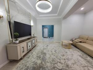 a living room with a couch and a flat screen tv at квартира in Aktau +4 photos