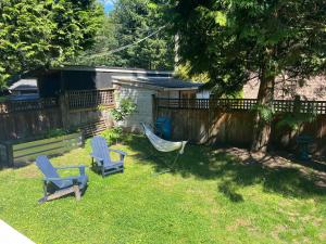 Un patio con dos sillas y una hamaca y una cerca. en Cozy and modern Pemberton Heights Suite, en North Vancouver