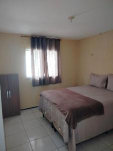 a bedroom with a large bed and a window at Casa Ubajara in Ubajara +3 photos
