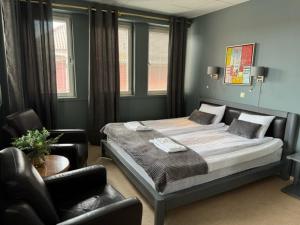 a bedroom with a bed and a chair and windows at Hotel Expo Stockholm in Stockholm