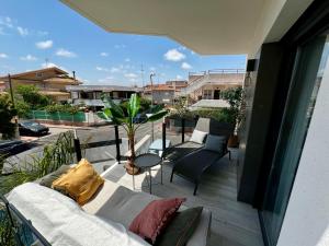 a balcony with a couch and chairs on a balcony at Air-conditioned Elisa Apartment with spacious sunroof lounge and swimming pool in San Javier