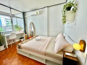 バンコクにあるFlow In Houseのベッドルーム1室(壁に植物が飾られたベッド1台付)