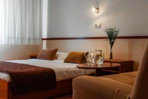 una camera d'albergo con due letti e un tavolo di Hotel Saraj a Sarajevo