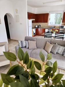 a living room with a couch and a kitchen at The Brightstay Paphos, 2 bed apt, Paphos Riviera, Universal in Paphos City