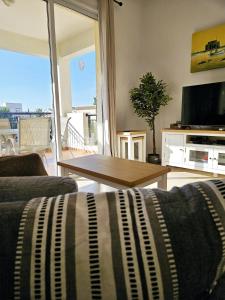 a living room with a couch and a table at The Brightstay Paphos, 2 bed apt, Paphos Riviera, Universal in Paphos City