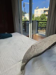 a bedroom with a bed with a view of a balcony at The Brightstay Paphos, 2 bed apt, Paphos Riviera, Universal in Paphos City +9 photos