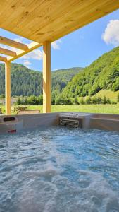a hot tub with a view of a mountain at Vama Chalet in Vama Buzăului