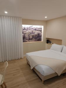 ein Schlafzimmer mit einem großen weißen Bett und einem Stuhl in der Unterkunft Pensión Vázquez in Vimianzo