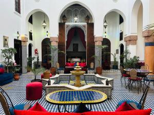 a courtyard with a fountain in the middle of a building at Riad Ahlam in Fès