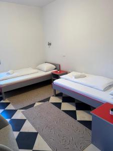 two beds in a room with a checkered floor at Hotel Dalija in Međugorje +42 photos