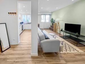 Una sala de estar con un sofá y un televisor. en Oasis Urbaine à Tarbes, en Tarbes