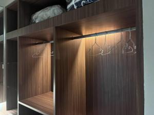 ein Holzschrank mit Kleiderbügeln darin in der Unterkunft panalee banna village独栋东区3卧室别墅Great Value Peaceful Retreat Near7-11 in Nong Prue + 25 Fotos