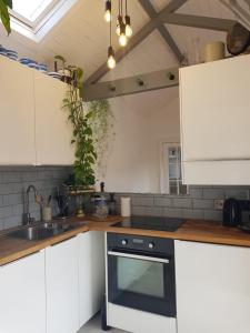 a kitchen with white cabinets and a black oven at Beautiful City Centre Apartment with Cathedral View in St. Albans
