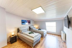 ein Schlafzimmer mit einem Bett, einer Couch und einem Fernseher in der Unterkunft Penthouse-Wohnung auf 2 Etagen in Wuppertal