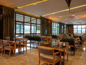 a restaurant with tables and chairs and windows at Calcalar Suit Hotel in Ula