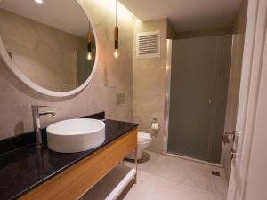 a bathroom with a sink and a mirror and a toilet at Calcalar Suit Hotel in Ula