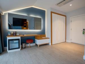 a room with a desk and a mirror on the wall at Calcalar Suit Hotel in Ula