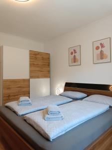 una camera da letto con due letti con asciugamani sopra di Ella Ferienwohnung ad Arnoldstein