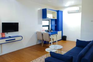 a living room with a blue couch and a table at Sribudaya Resort in Payaarp