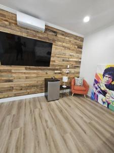 Una sala de estar con un televisor de pantalla plana grande en una pared. en NEW Beach Quinta 2bed 2 bath Beautiful Yard Tranquility, en Lake Worth