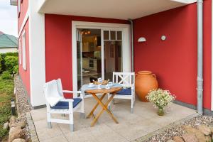 a patio with a table and two chairs and a vase at STRANDNAH STRANDLÖWE KÜHLUNGSBORN Ostsee in Kühlungsborn +18 photos