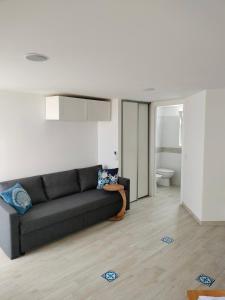 a living room with a black couch and a bathroom at Attichetto monolocale vista mare terrazzatissimo Asterspace in Anzio