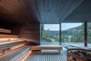 a sauna with a bench and a large window at Pytloun Wellness Hotel Harrachov in Harrachov