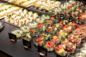 a buffet filled with different types of food in bowls at Pytloun Wellness Hotel Harrachov in Harrachov