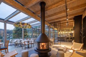 a fireplace in a restaurant with tables and chairs at Pytloun Wellness Hotel Harrachov in Harrachov
