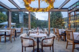 a restaurant with tables and chairs and a large window at Pytloun Wellness Hotel Harrachov in Harrachov
