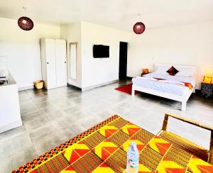 a living room with a bed and a colorful rug at KaChai Hotel Fort Portal in Kyarusozi