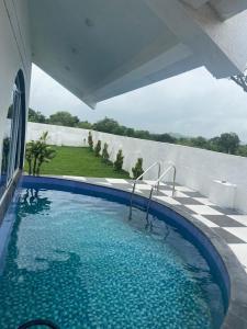 a swimming pool with a view of a house at Bhaktivilla in Talegaon Dābhāde