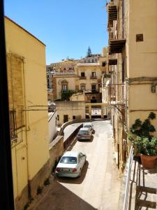 een paar auto's geparkeerd op een straat met gebouwen bij Kalos Rooms in Agrigento