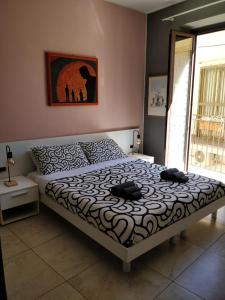 een slaapkamer met een bed met twee hoeden erop bij Kalos Rooms in Agrigento