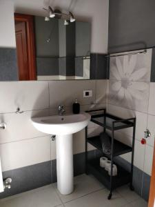 een badkamer met een wastafel en een spiegel bij Kalos Rooms in Agrigento