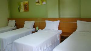 a room with two beds with white sheets at Hotel Elite 1 in Nossa Senhora dos Milagres