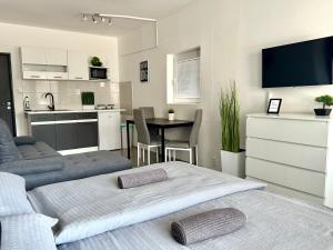 a room with two beds and a kitchen with a table at City Apartment in Štúrovo