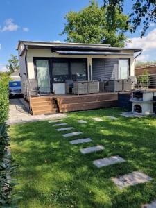 a manufactured home with a deck and lawn at Ferienhaus am See-2 in Hungen