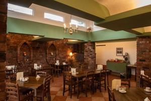 a dining room with wooden tables and chairs at Abbots Mead Hotel in Shrewsbury