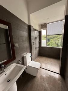 a bathroom with a toilet and a sink and a window at Varsity Villa in Kandy +62 photos