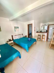 a bedroom with two beds and a kitchen at MARESIA Porto da Barra in Búzios