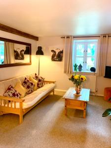 un salon avec un canapé et une table dans l'établissement Daisy Cottage, à Child Okeford