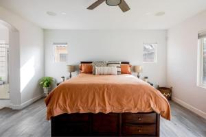 1 dormitorio con 1 cama con colcha de color naranja en Private Desert Pool Hot Tub BBQ, en Indio