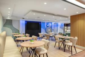 a restaurant with tables and chairs and a flat screen tv at Danubius Hotel Hungaria City Center in Budapest