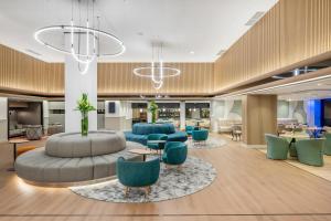 a hotel lobby with blue chairs and tables at Danubius Hotel Hungaria City Center in Budapest