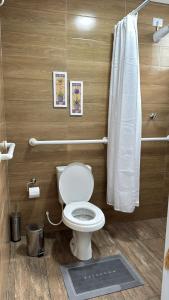 a bathroom with a toilet and a shower curtain at La Estância Flats in Iguape +10 photos