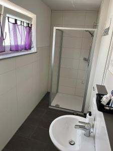 a bathroom with a sink and a shower at MW Apartments B1 in Lauchheim +20 photos