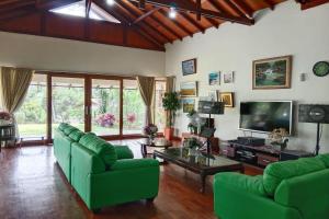 a living room with green couches and a tv at Nataka Green in Kopo 2
