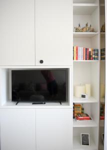 a white cabinet with a flat screen tv in it at Forest View Hideaway in Braşov